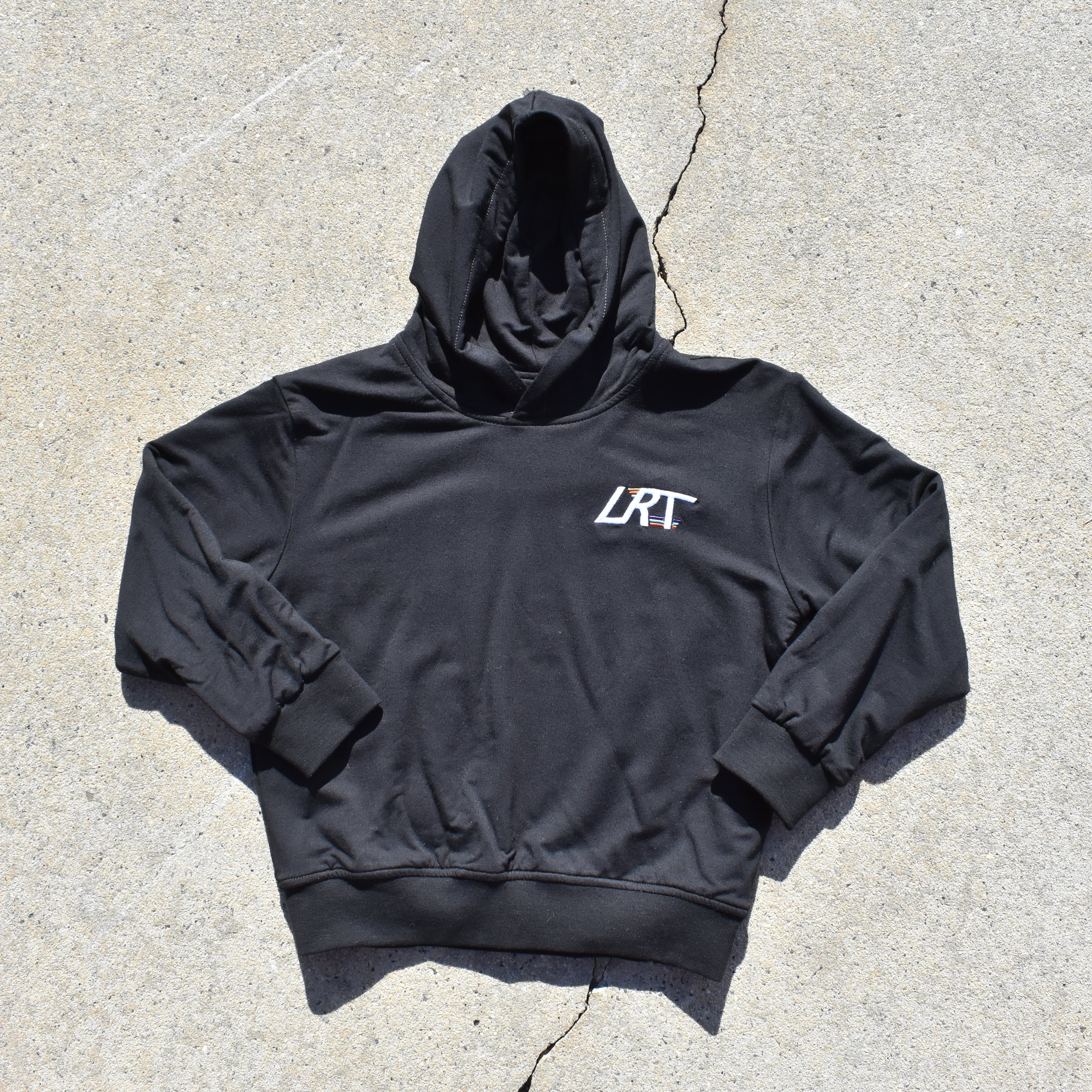 Black hoodie with a logo on a concrete surface