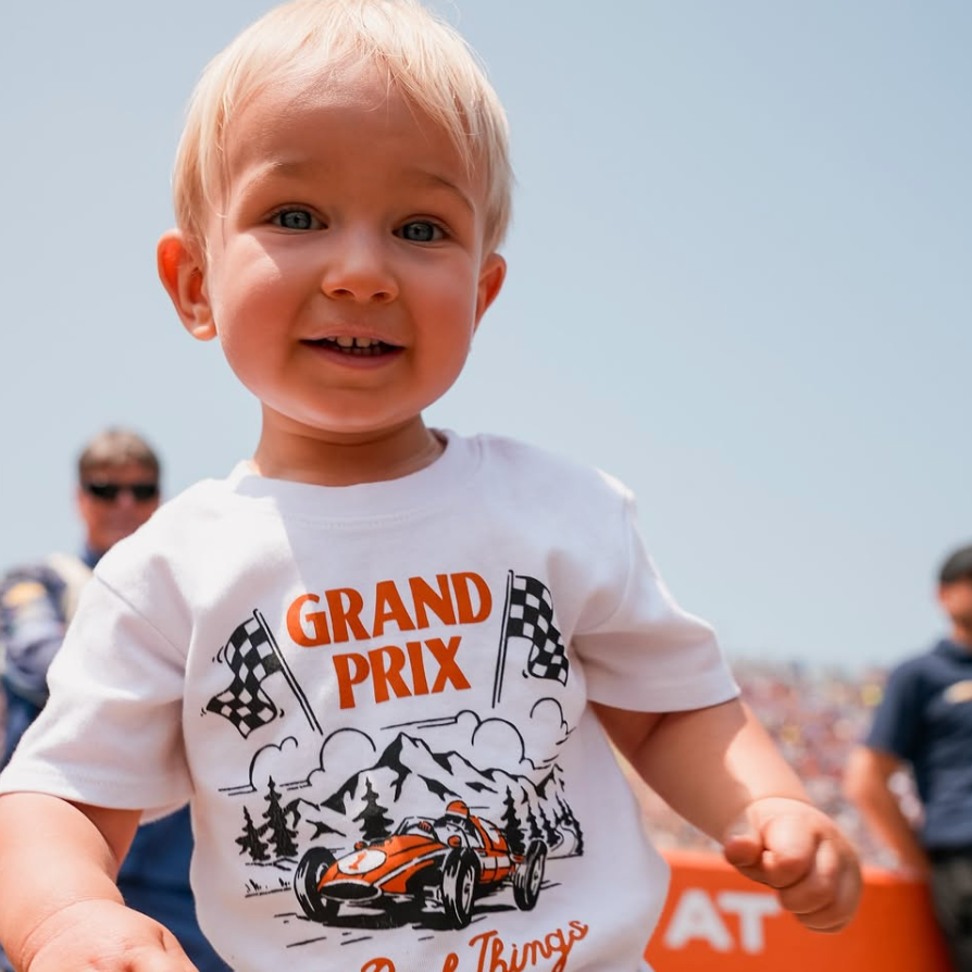 Child wearing a 'Grand Prix' themed t-shirt with a race car graphic.