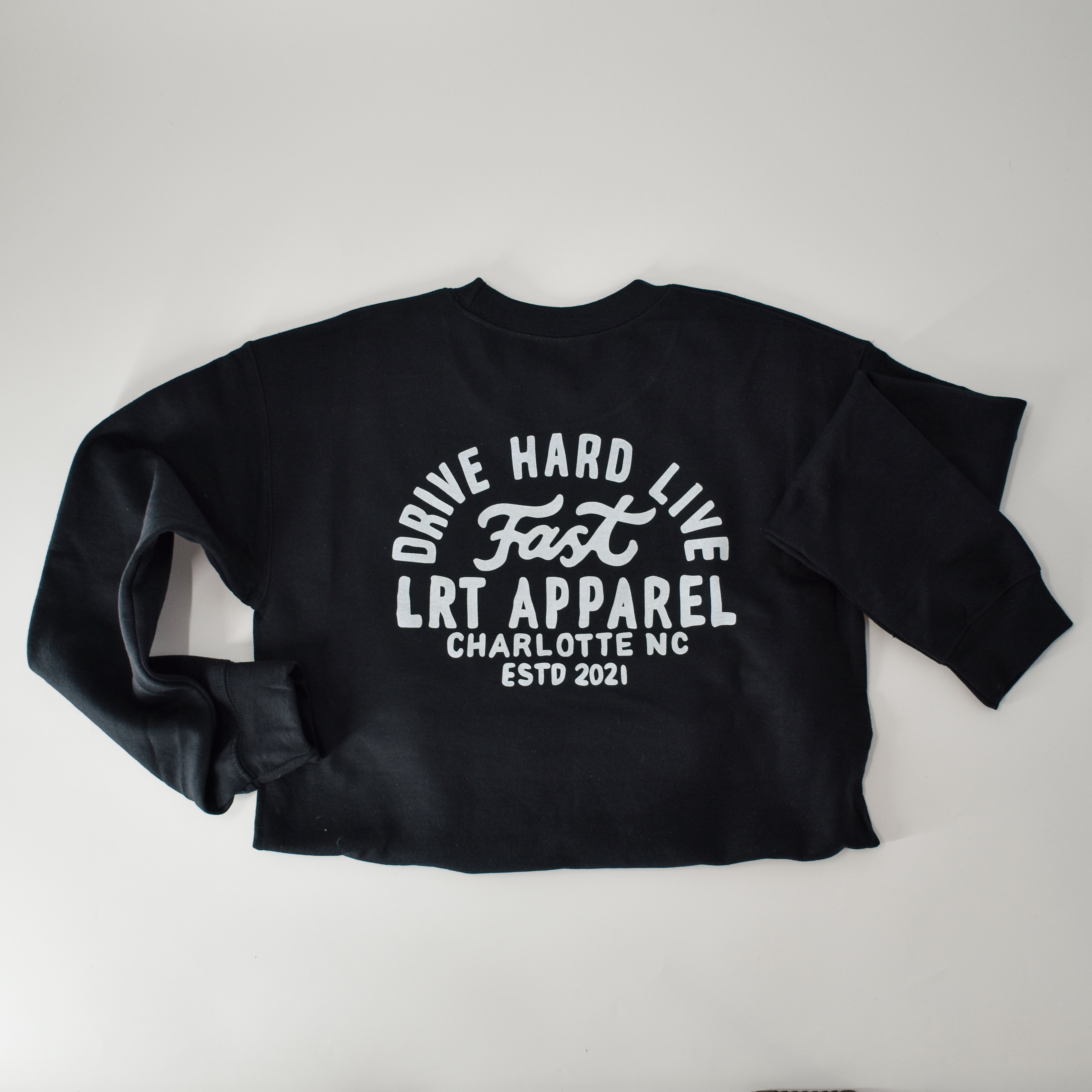 Vintage motorsport-inspired black cotton-polyester crewneck with white bold racing slogan, displayed to highlight graphic and fabric details