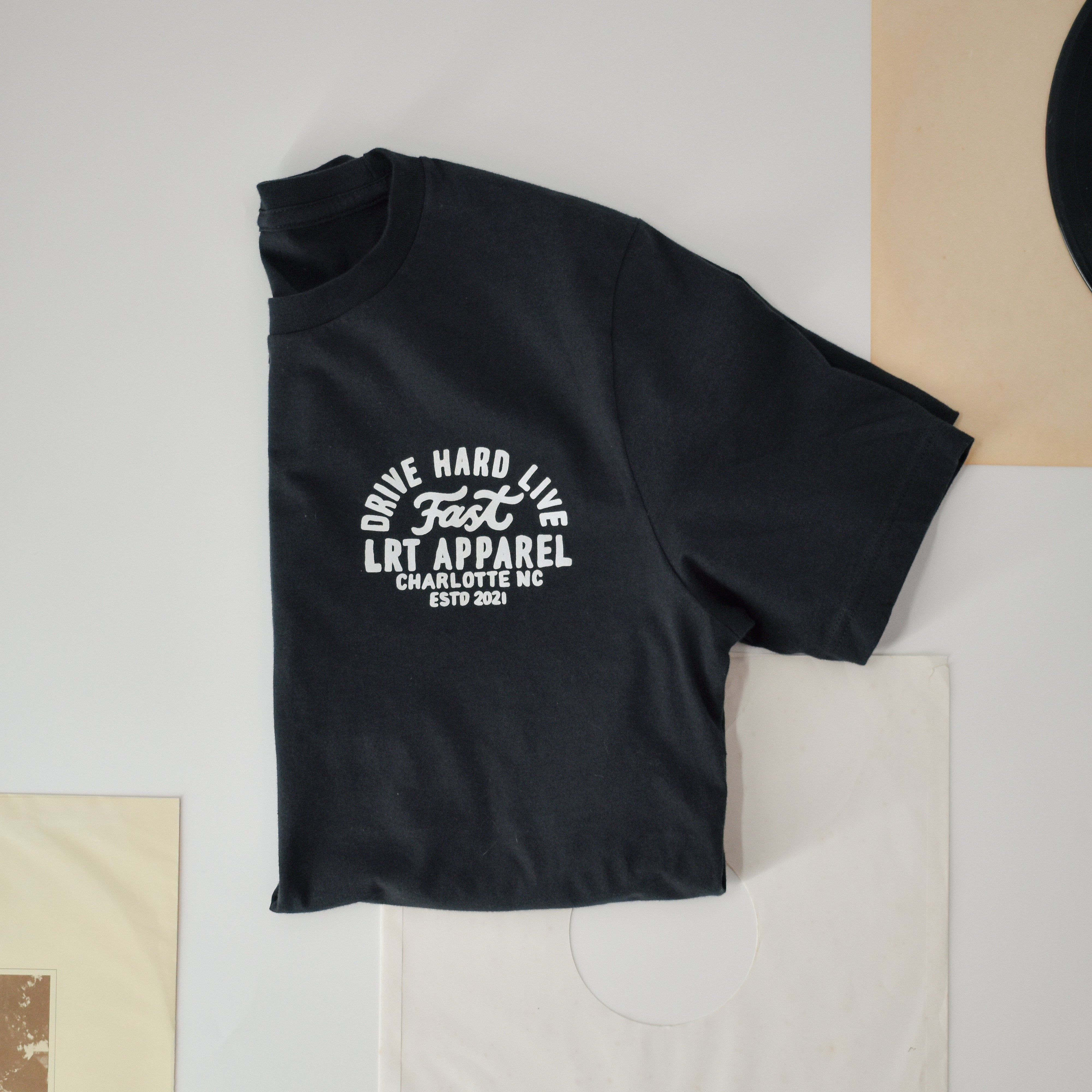 Vintage motorsport-inspired black cotton t-shirt with bold white racing slogan, showcasing retro design elements