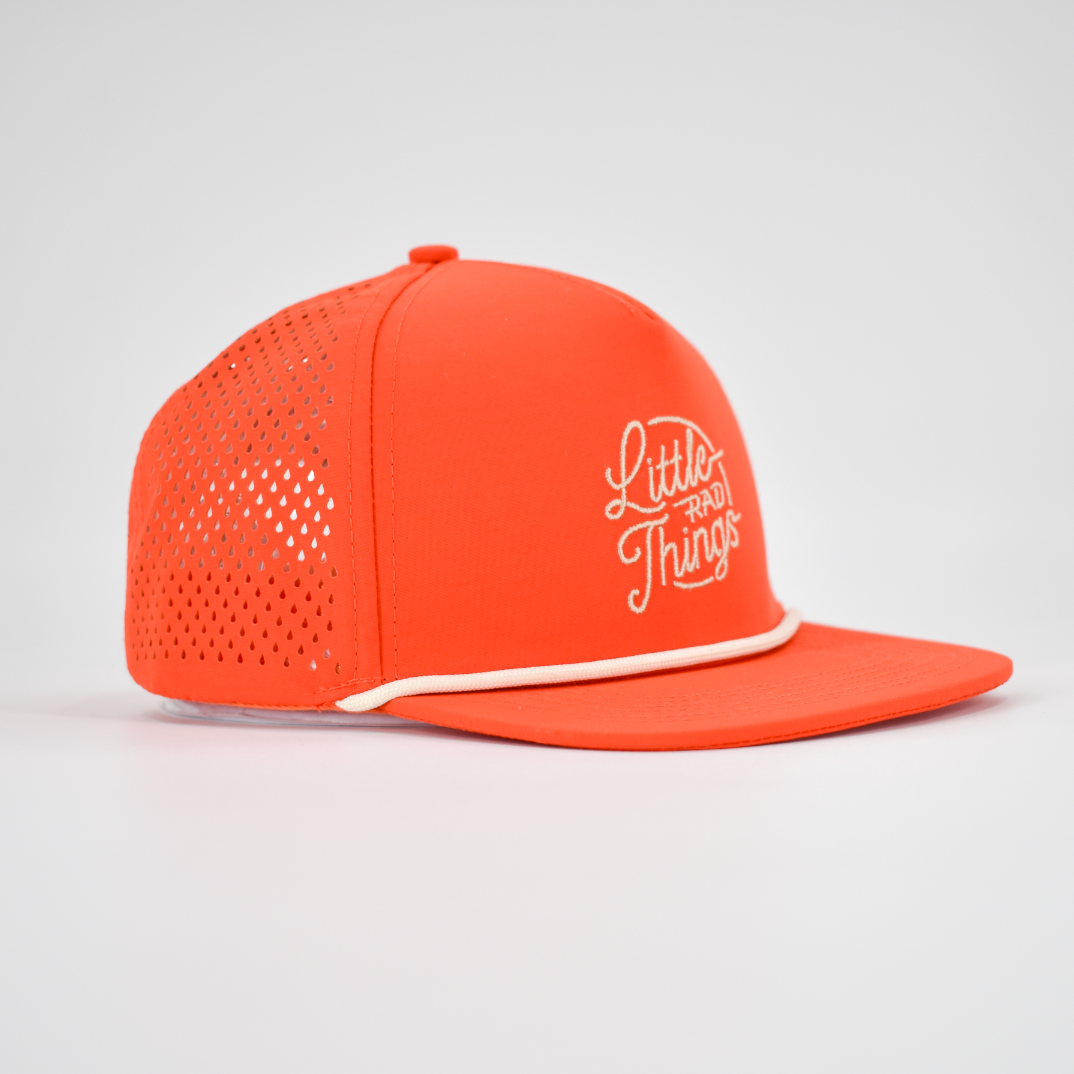 Motorsport-inspired orange snapback hat with slightly curved bill, featuring white retro LRT logo and innovative laser-cut breathability